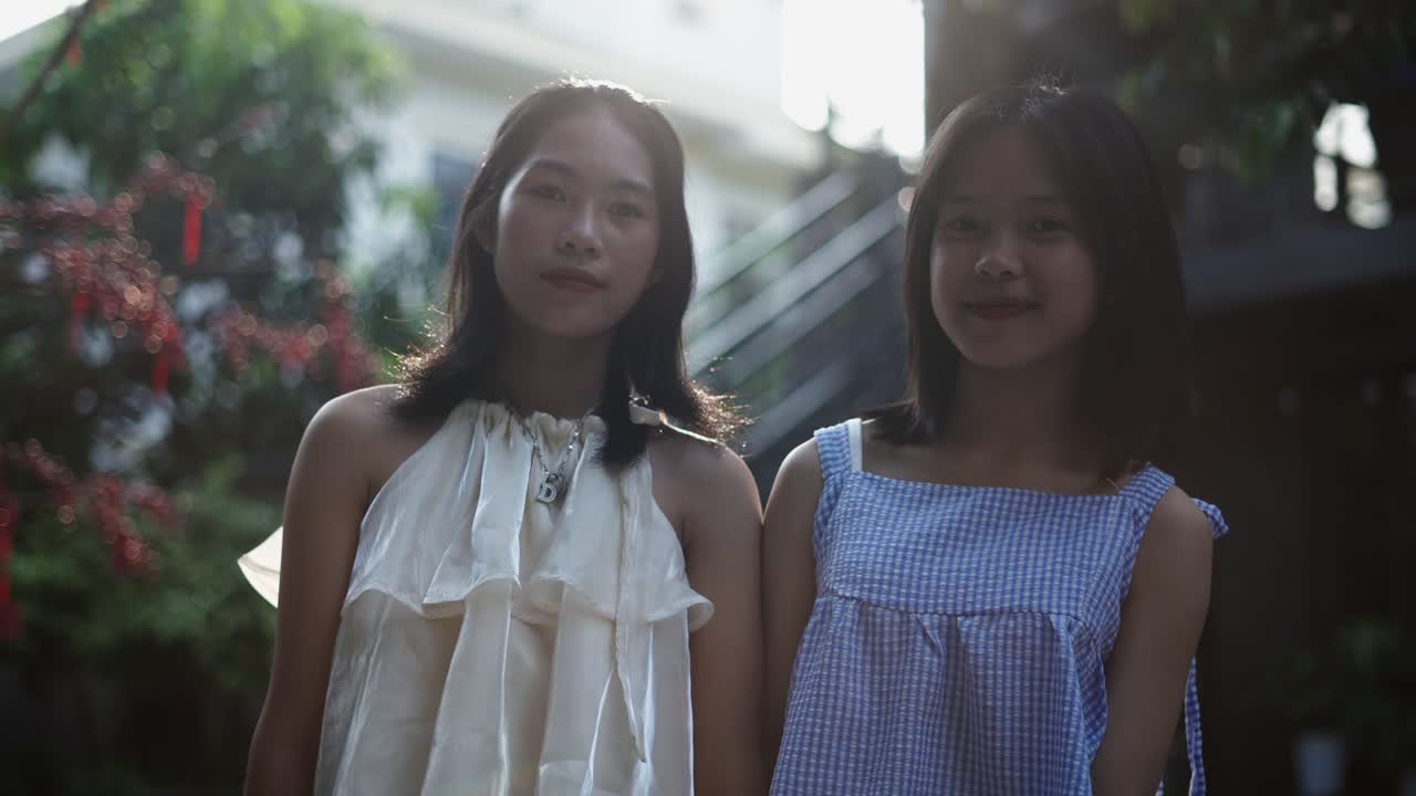 Two young women standing outdoors, smiling