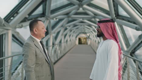 arab and asian business partners shaking hands