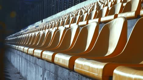 sillas amarillas en un estadio vacío detrás de una valla de metal, 4k
