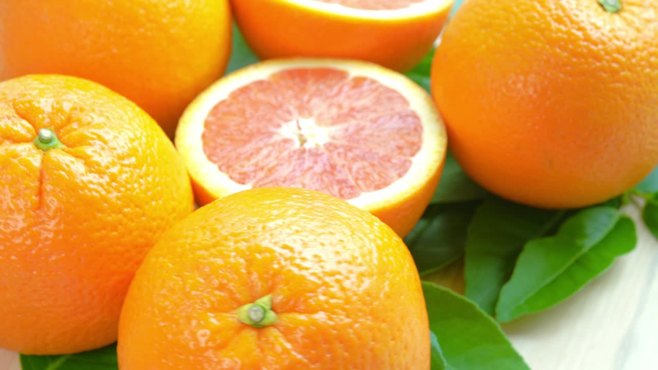 나무 바탕에 바구니에 오렌지 잎, 위쪽 뷰 회전 그레이프프루트 또는 나무 바탕에 카라 카라 오렌지, 4k 해상도.