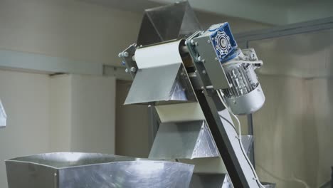 Feeding conveyor for bulk products. Automatic belt conveyor at a food factory. Production of corn snacks