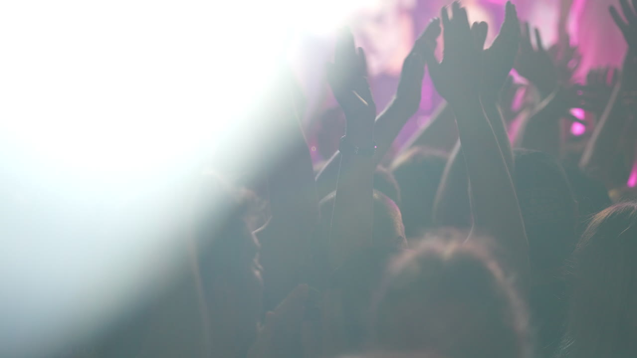 Folla di mani alzate per l'eccitazione a un vibrante concerto di musica con luci colorate ed energia