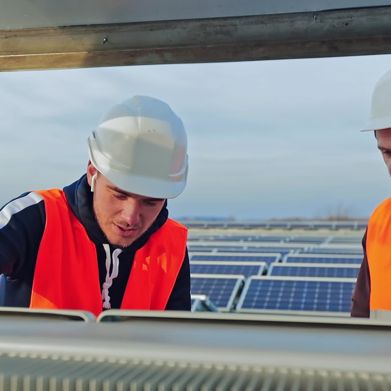 Solar generation technologies. Male workers in protective uniform provide installation of solar panels on the background of a modern electricity farm.