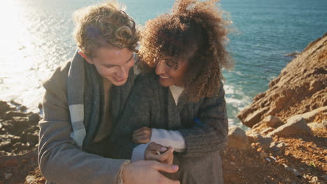 closeup happy lovers hug marine cliff. curly woman blonde man holding hands