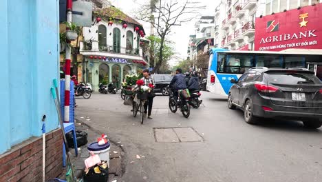 un vendedor de flores navega por las concurridas calles de hanoi