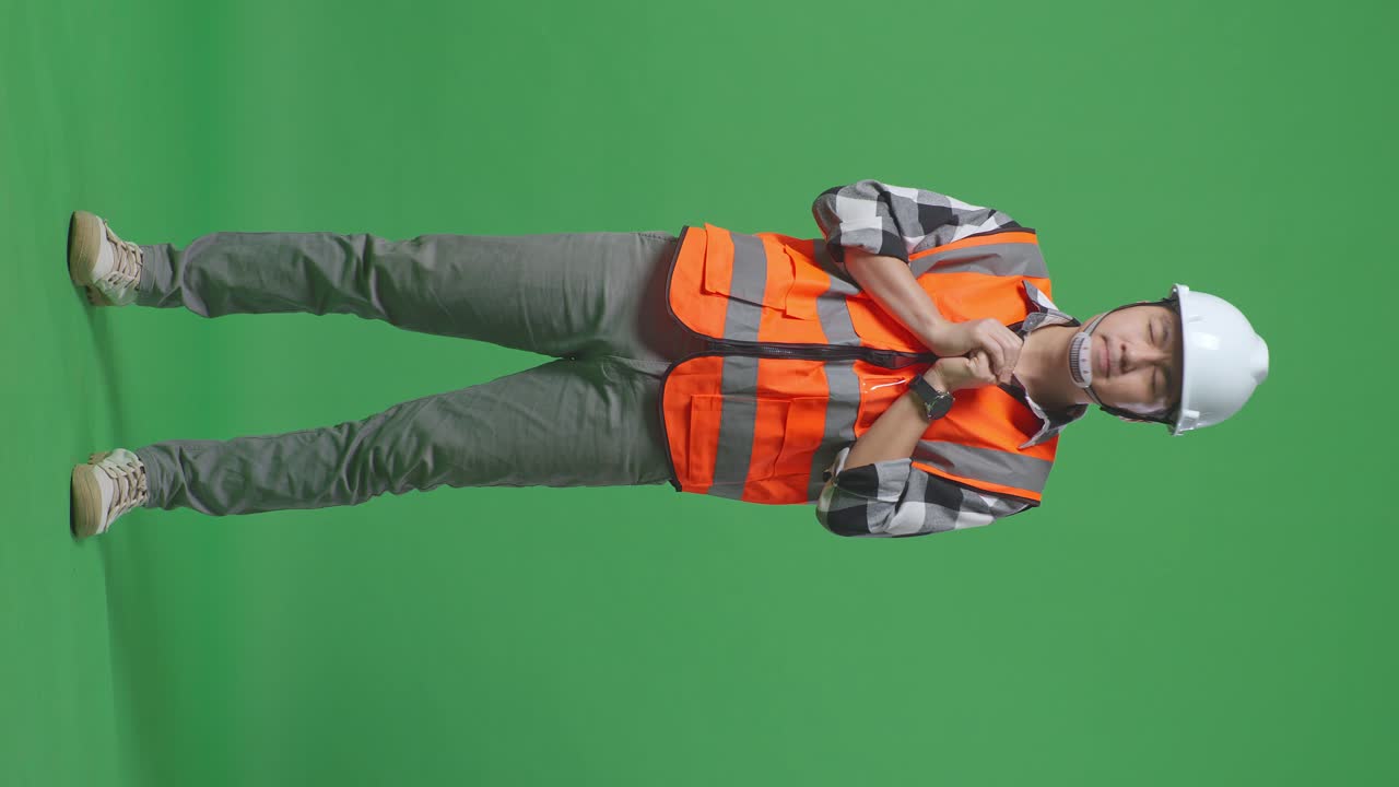 Full Body Of Asian Male Engineer With Safety Helmet Pray For Something While Standing In The Green Screen Background Studio