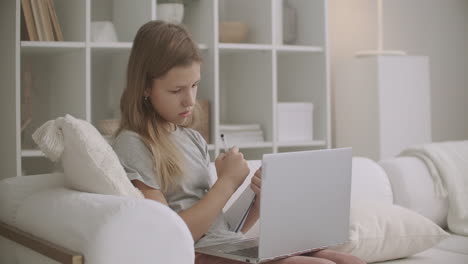 school girl is communicating with teacher by video chat on laptop doing homework at home distant education for secondary school