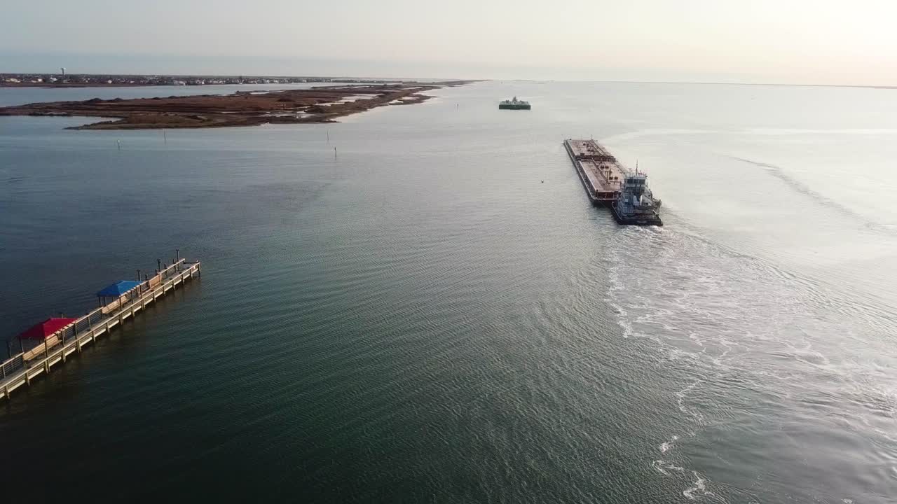 일몰 근처의 라구나 마드레에 있는 걸프 연안 수로를 따라 운행하는 두 개의 대형 바지선의 공중 전망