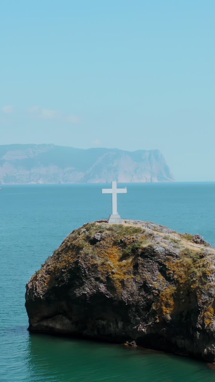 바위가 있는 해안 절벽 위의 십자가