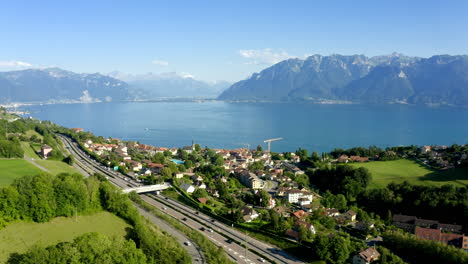 cars driving on highway a9 near chexbres village, overlooking the beautiful lake leman and mountain alps on the background, switzerland - aerial drone