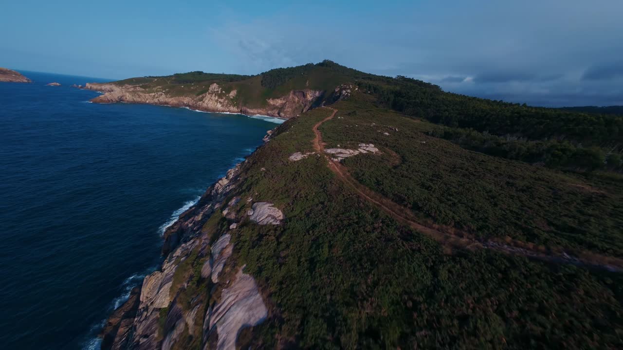 Volo FPV al tramonto sull'oceano, con il sole che scompare all'orizzonte e riflessi dorati sull'acqua, che trasmette libertà, velocità e un'atmosfera tranquilla e cinematografica