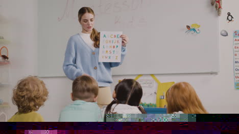 female teacher teaching letters of the alphabet to her pupils in a montessori school 1