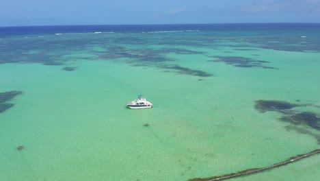 Vuelta-Aérea-De-Un-Barco-Sobre-Aguas-Claras-Cerca-De-Cap-Cana