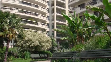 camera panning over the residential apartments and benches laid in front of the buildings