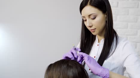 patient getting head injections. anti hair loss injection in cosmetology clinic