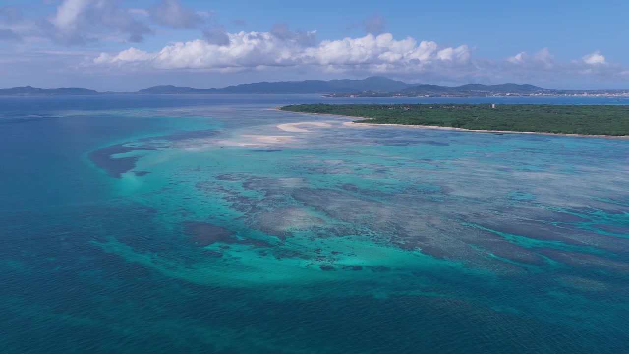 Riprese aeree orizzontali con panoramica a sinistra e carrello a destra sopra le barriere coralline e la laguna turchese di Kondoi Beach e Kaiji Beach, Isola di Taketomi, Okinawa, Giappone.