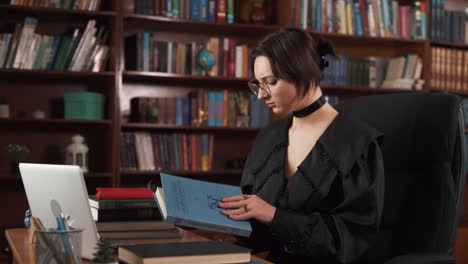 The-girl-is-sitting-at-the-table-with-many-books-on-it