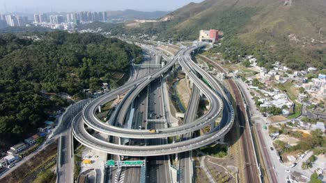 Verkehr-Auf-Einem-Massiven-Autobahnkreuz-Mit-Mehreren-Ebenen-Und-Schleifenförmiger-Straße-In-Hongkong,-Luftbild