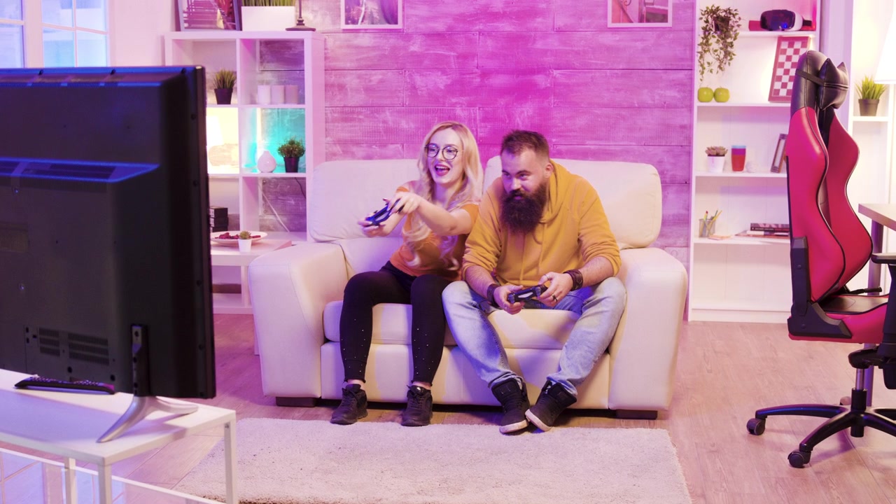Blonďatá žena si užívá online hraní vedle kamaráda