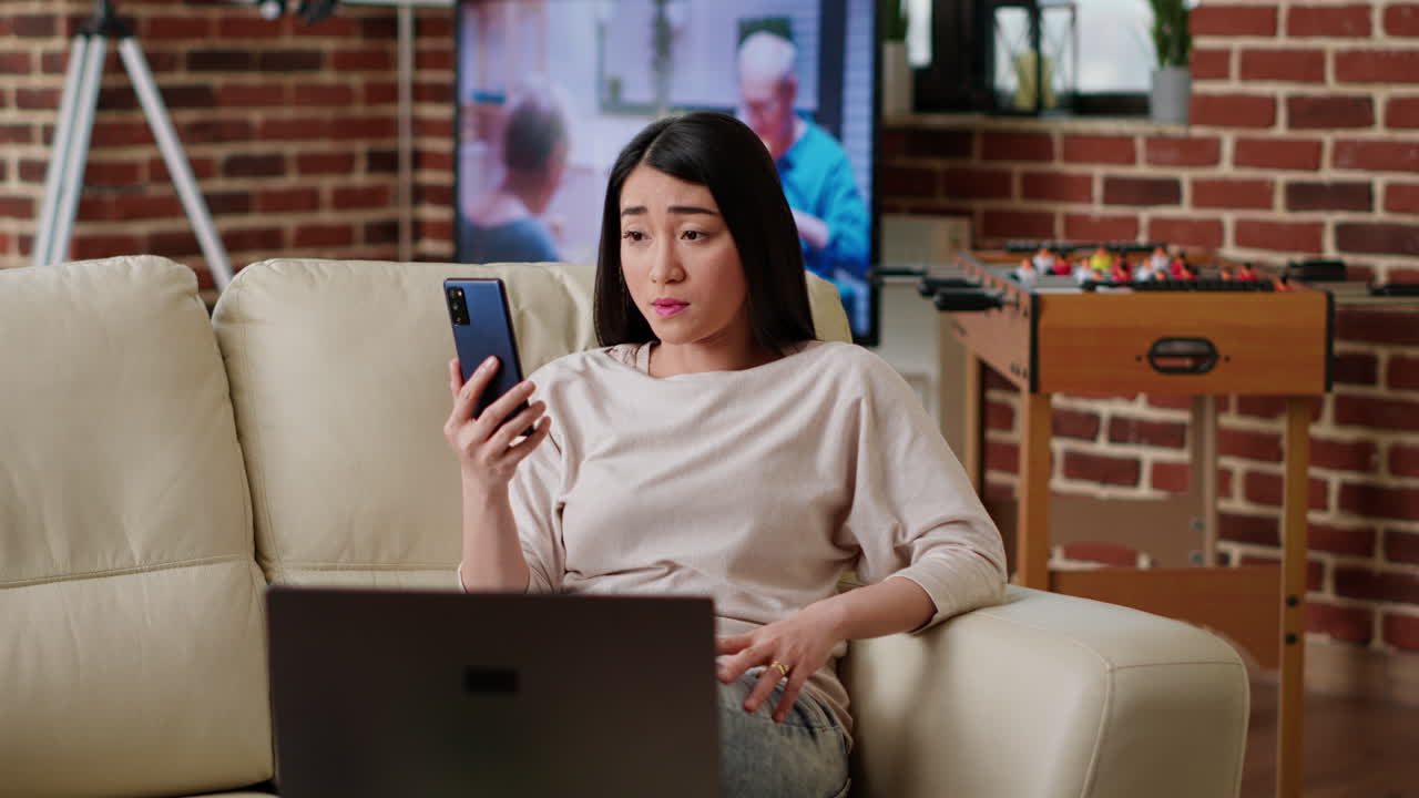 소파에서 스마트폰을 사용하는 여성