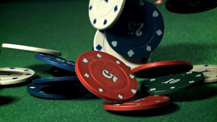 Rallentatore di fiches da gioco che cadono su un tavolo da poker verde.