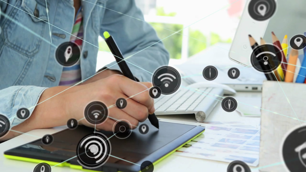 Woman placing stylus on tablet and drawing at desk, generating animated tech icons mapping network