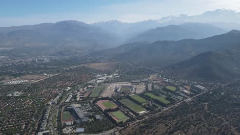 high-altitude perspective showcasing a stadium and surrounding sports fields nestled within a picturesque mountain valley