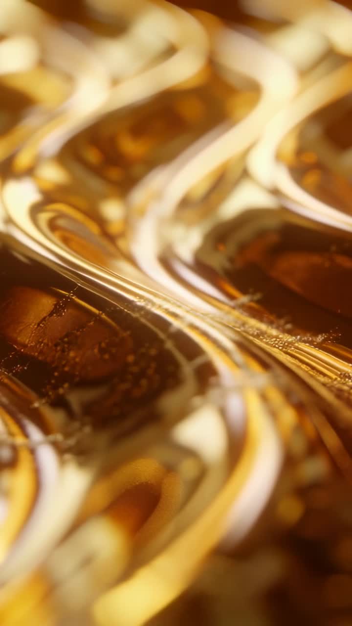 Video verticale: Messa a fuoco che cambia, una pellicola dorata rivela creste, riflessi e bolle, in uno studio macro.