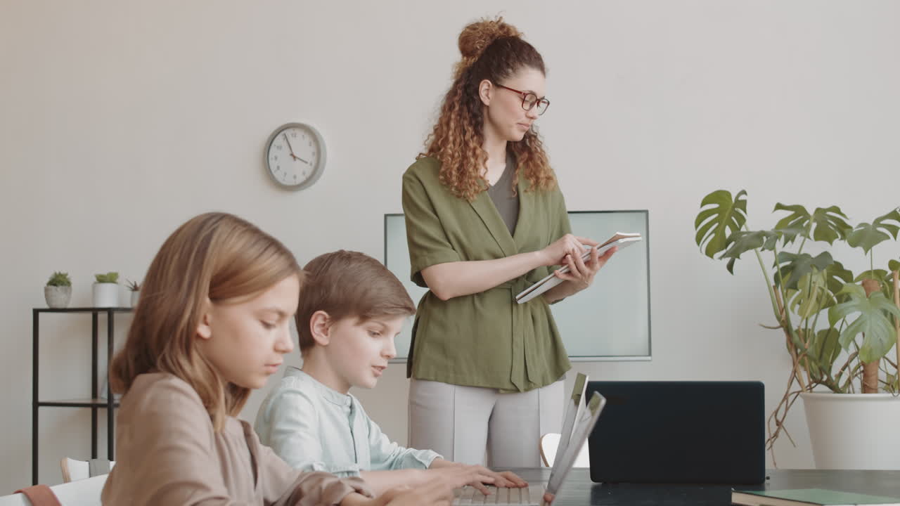 Woman Teaching IT to Diverse Children