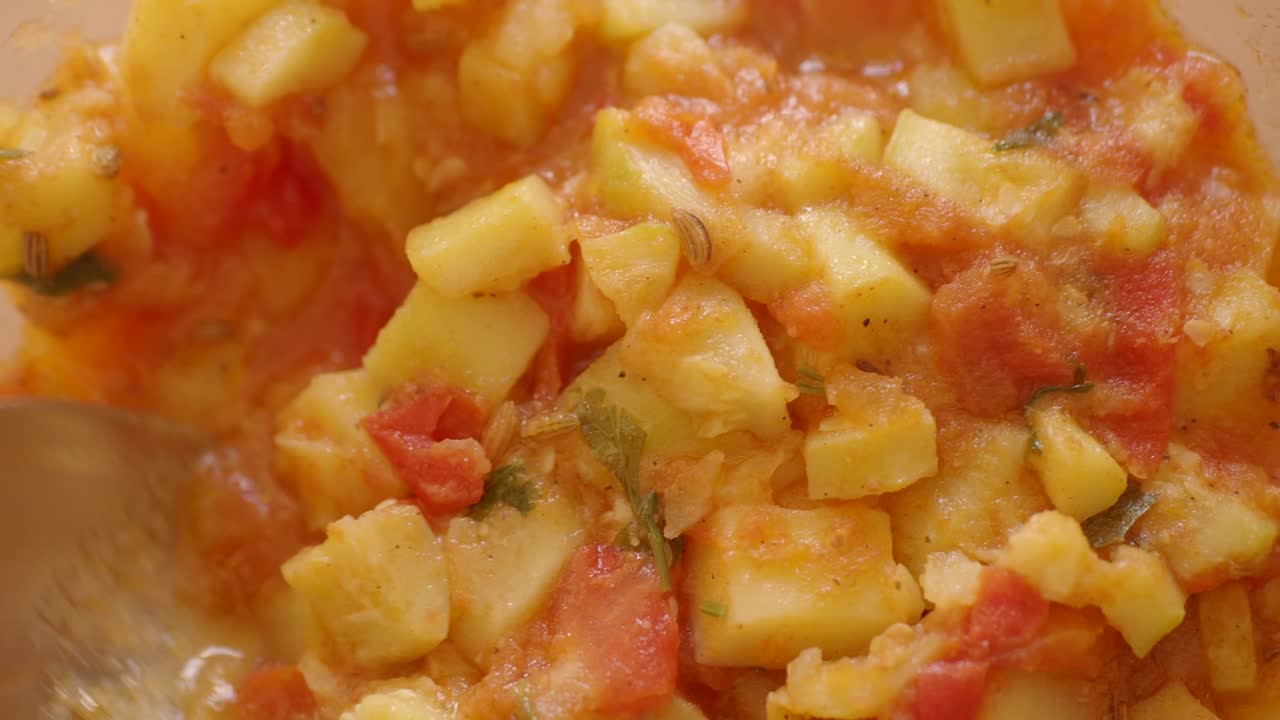 Close-up of a Hearty Potato and Tomato Stew being Stirred