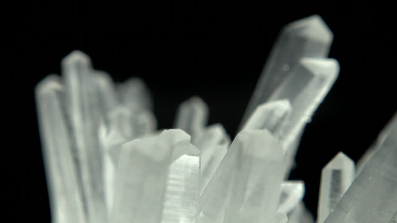 rotación sin problemas de un mineral blanco (cuarzo) frente a un fondo negro