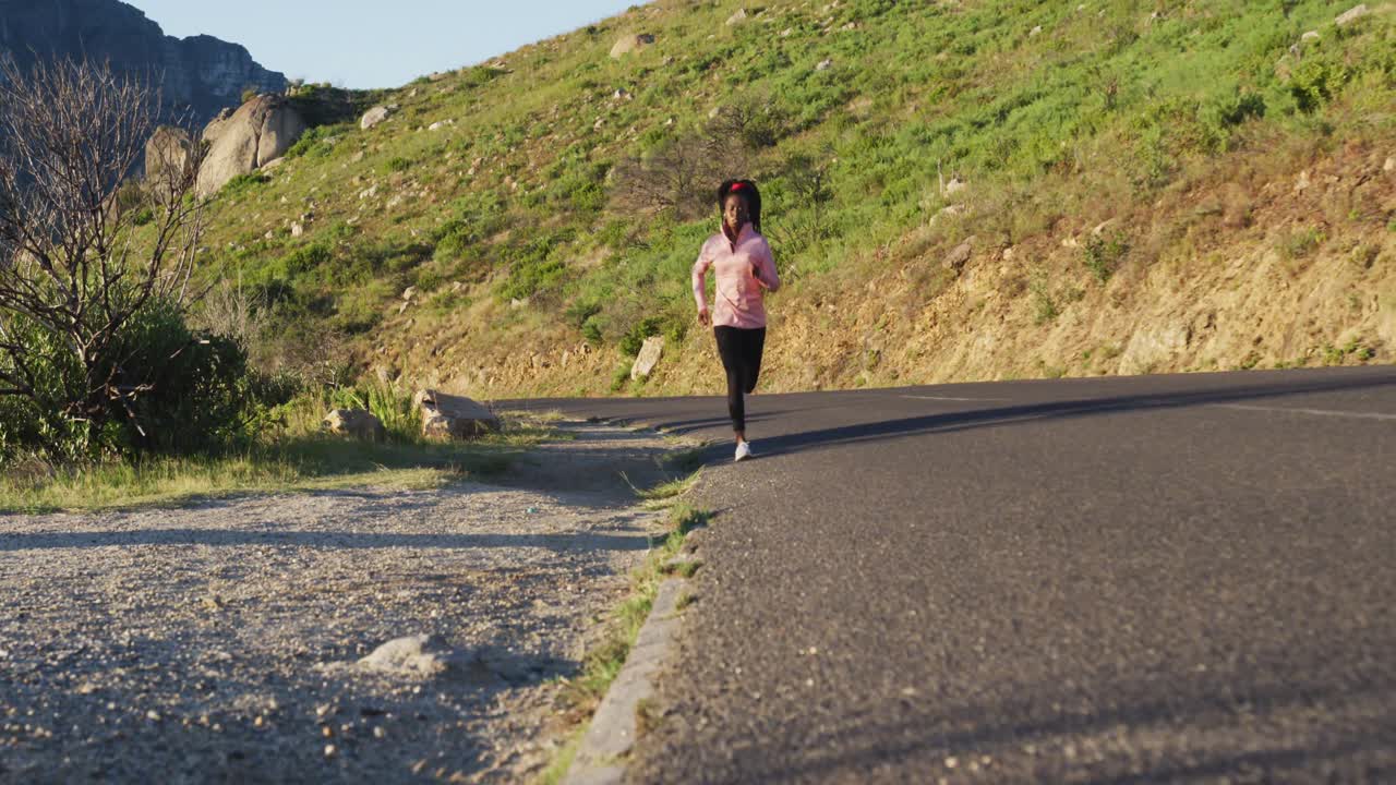 아프리카계 미국인 여성 이 해가 지는 동안 야외 에서 운동 을 하고 시골 에서 달리고 있다