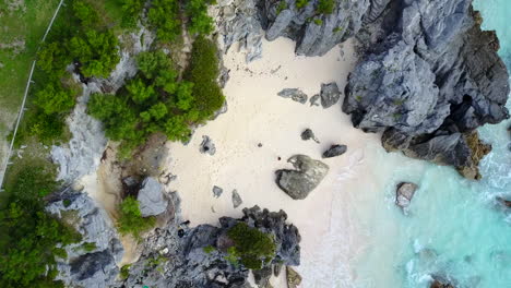 aerial drone shot over a small beach by a park in bermuda