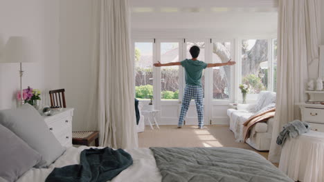 Un-Joven-Divertido-Bailando-En-El-Dormitorio-Divirtiéndose-Celebrando-Sentirse-Positivo-Disfrutando-De-Un-Estilo-De-Vida-Exitoso-Haciendo-Un-Baile-Tonto-En-Casa-El-Fin-De-Semana-Por-La-Mañana-Usando-Pijamas