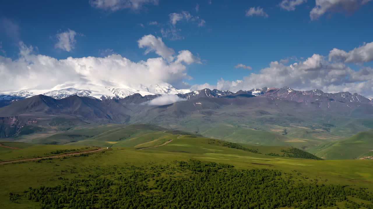Oblast Elbrus. Let nad vysokohorskou plošinou. Krásná přírodní krajina. V pozadí je vidět hora Elbrus.
