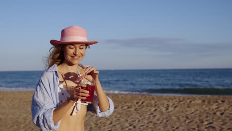 mujer disfrutando de un cóctel en la playa