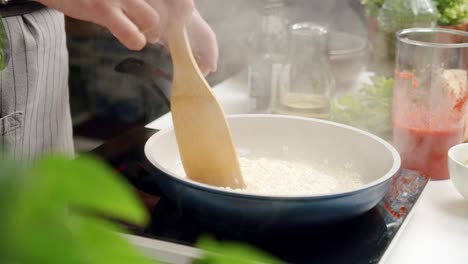 Unrecognizable-cook-preparing-risotto-in-pan