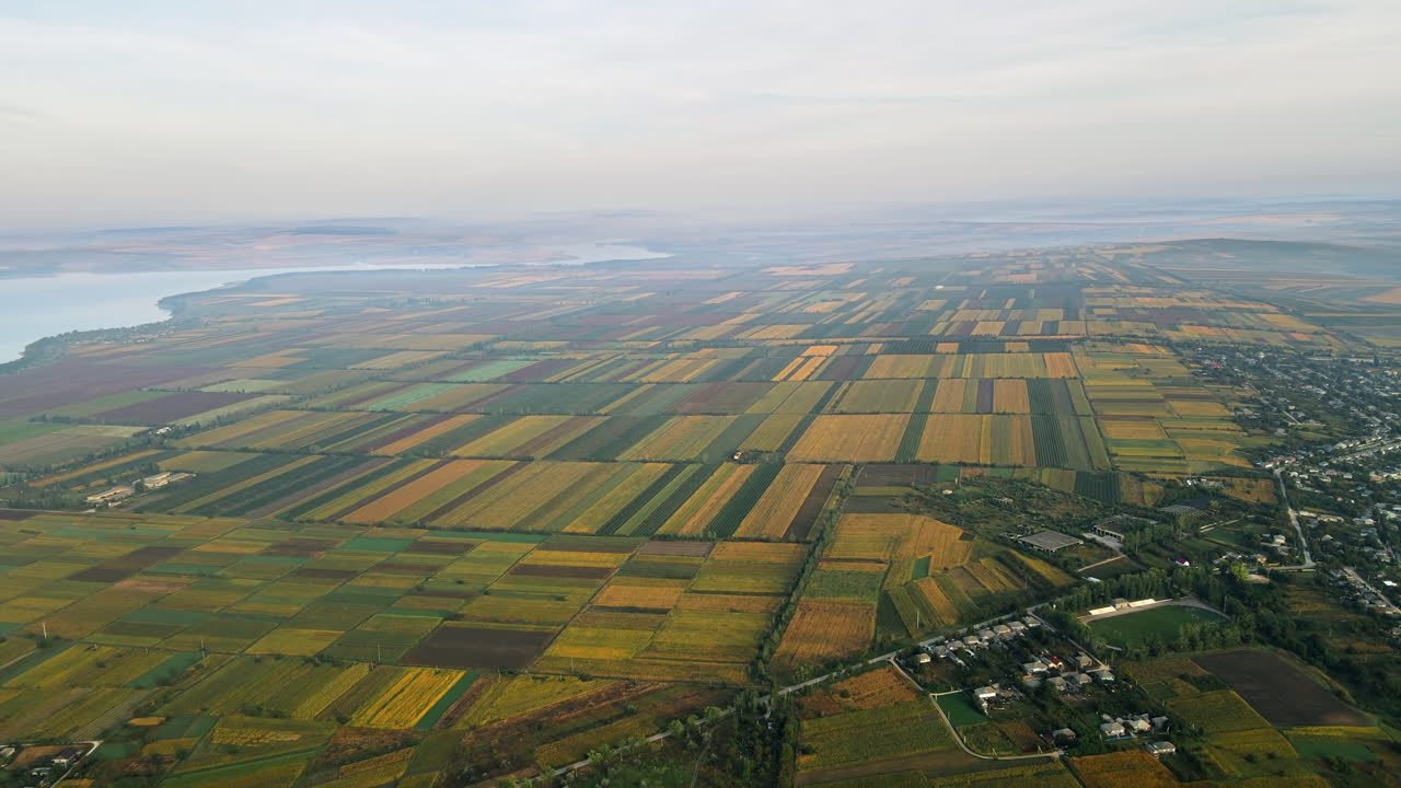 Aerial drone view of the Duruitoarea natural reservation in Moldova. River and fog in the air, hills and fields, village with roads and greenery