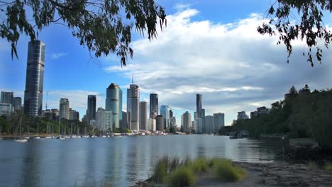 Beautiful-view-through-overhanging-trees,-down-the-Brisbane-River-towards-Brisbane's-Central-Business-District