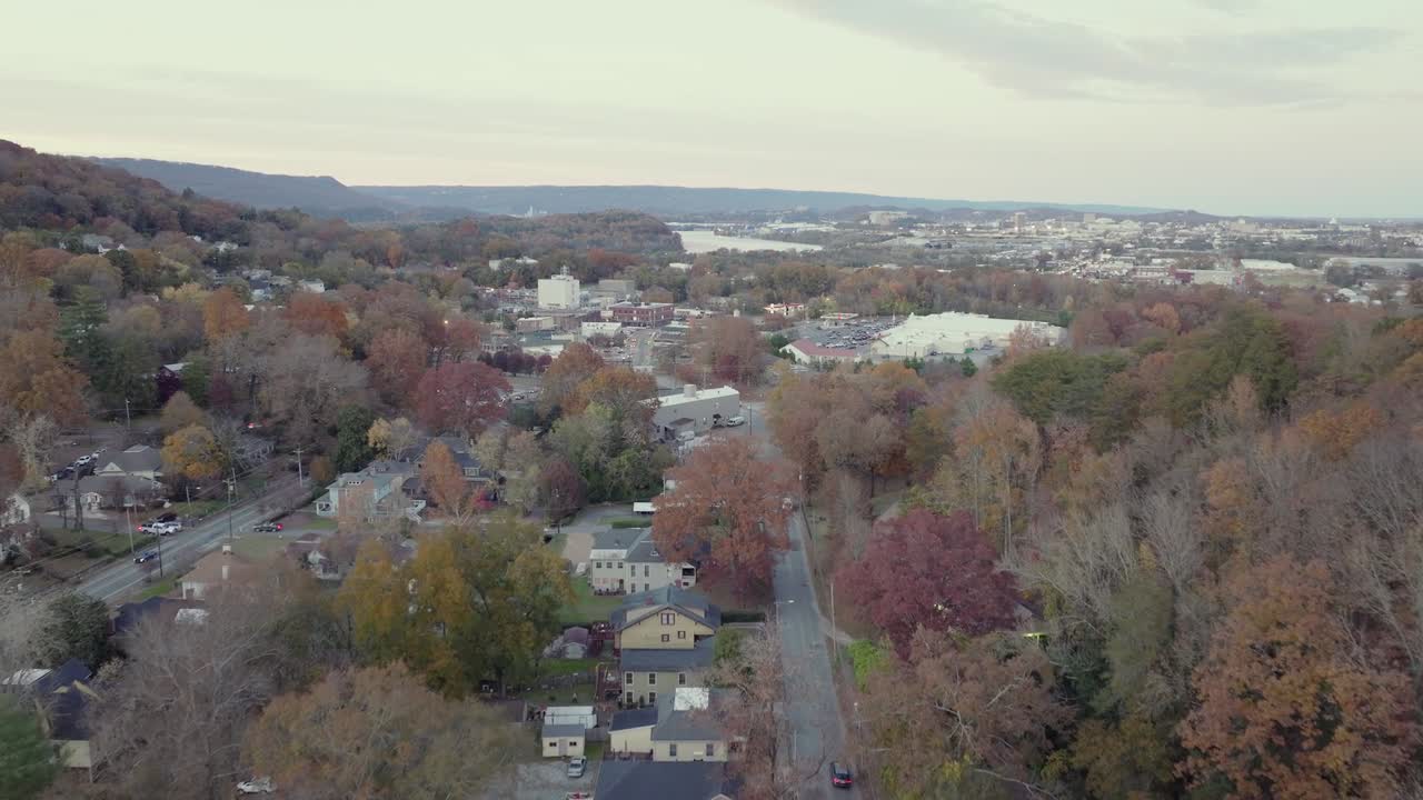 Drone footage shows scenic town of Buena Vista in Virginia surrounded by colorful autumn trees hills and distant river under soft sky capturing peaceful suburban charm in United States
