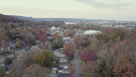 drone footage shows scenic town of buena vista in virginia surrounded by colorful autumn trees hills and distant river under soft sky capturing peaceful suburban charm in united states