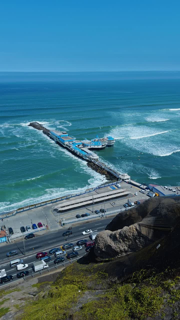 High angle vertical establishing of La Rosa Nautica in Lima Peru beach, ocean road below clifs
