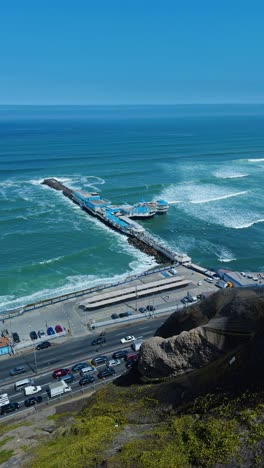 high angle vertical establishing of la rosa nautica in lima peru beach, ocean road below clifs