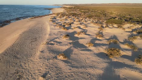 4k bezludnej skalistej plaży o zachodzie słońca, zdjęcie lotnicze