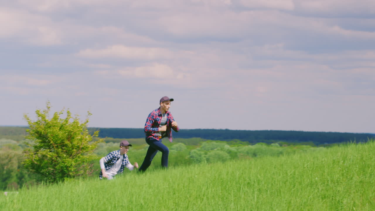두 어린 십대 소년이 푸른 언덕을 따라 달리다 1