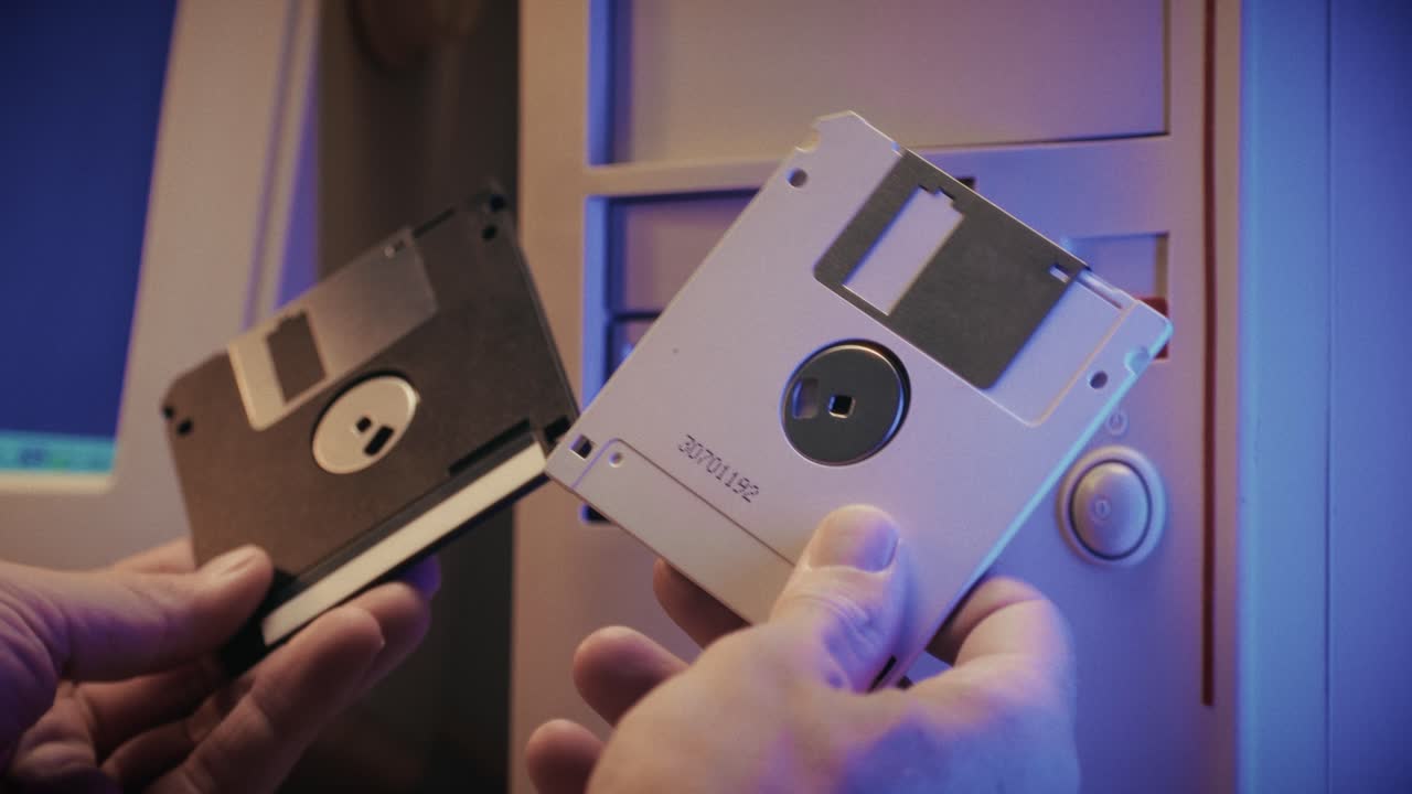 Using diskette for old computer. Music recorder, playing retro computer games. Vintage device for office, obsolete technology. . High quality 4k footage