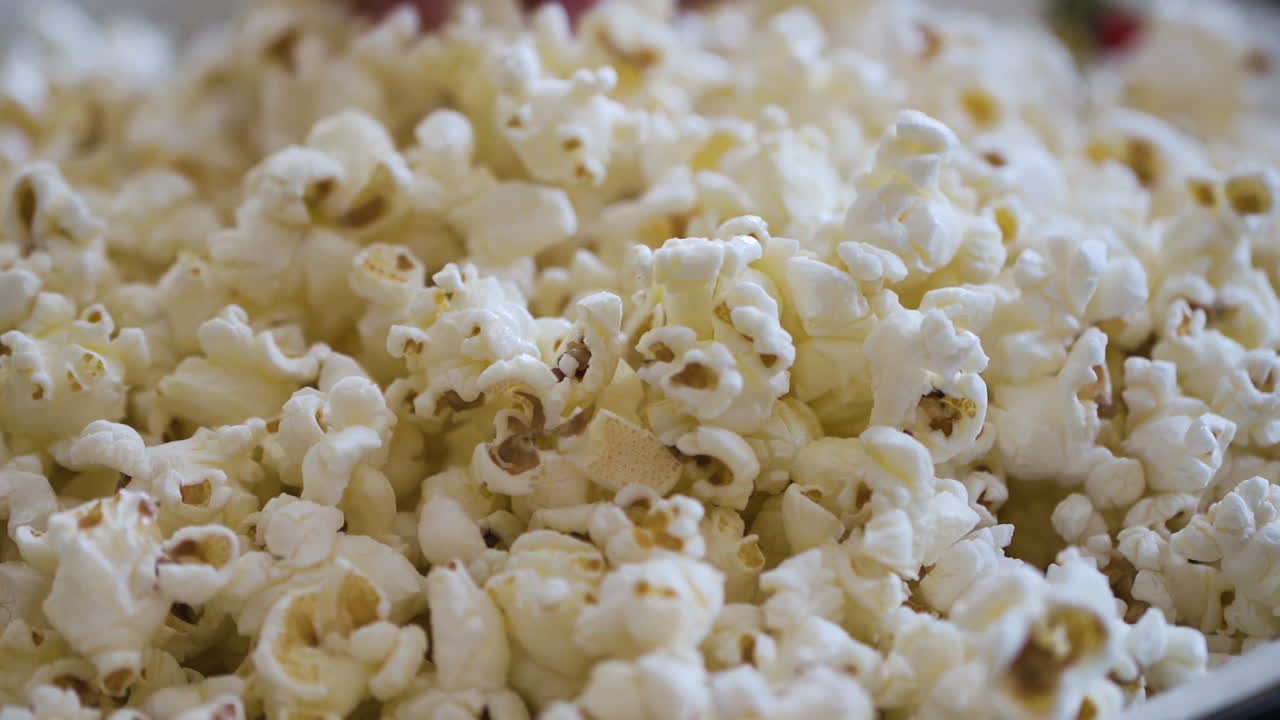Kid's hands grabbing popcorn from a large bowl