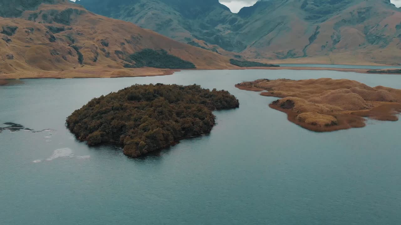 una foto aérea de una isla cubierta de árboles en el medio de un lago en el parque nacional de ecuador sangay