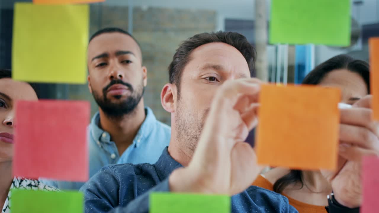 imágenes de video de 4k de un grupo de hombres de negocios discutiendo ideas en notas adhesivas