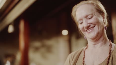 an elderly woman smiling and looking down